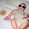 baby, casual_pose, child, cream_shorts, cute, face, foot, four_months, hand, indoor, infant, light, lotion_tube, milestone, portrait, relaxed, striped_shirt, sunglasses, white_quilt, wooden_plaque