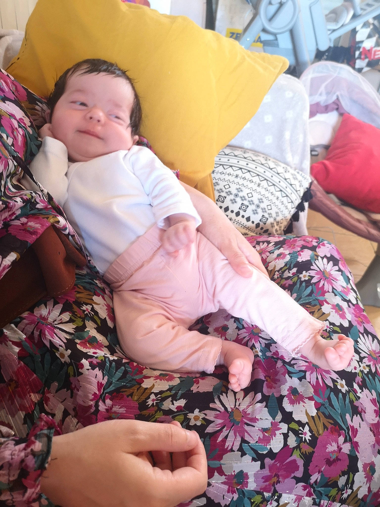 Assia participe au concours pour gagner de l'argent avec cette photo : baby, bedding, child, comfort, couch, finger, happy, human_leg, interaction, lap, linens, magenta, pattern, person, pink, purple, room, sitting, textile, thigh