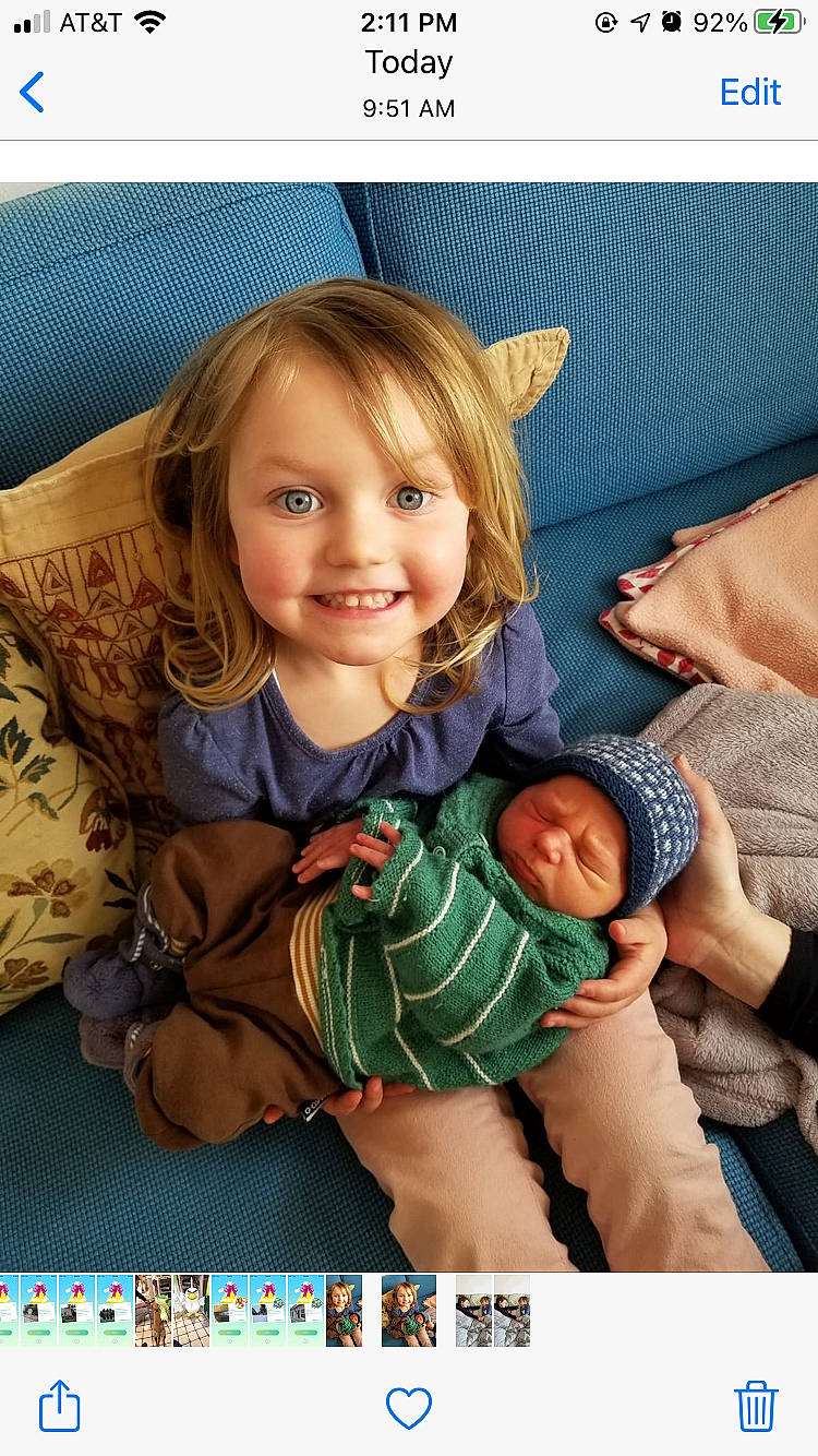 Greta joined the competition — help win amazing prizes! baby, baby_products, baby_toddler_clothing, child, comfort, couch, fun, happy, headwear, joy, lap, linens, pattern, person, photo_caption, play, portrait_photography, product, room, sitting