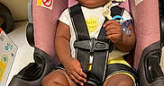 Naomi joined the competition — help win amazing prizes! baby, black_shoes, car_seat, child, clothing, curious, cute, expression, floor, holding, indoors, infant, pacifier, person, portrait, safety_harness, sitting, straps, warning_label, young_child