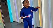 Damere joined the competition — help win amazing prizes! toddler, child, blue_clothing, hoodie, sneakers, toy, light_up_toy, indoor, modern, colorful, panels, floor, smiling, happy, standing, person, playful, young_child, casual_wear, bright