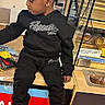 Damere joined the competition — help win amazing prizes! child, braided_hair, black_clothing, hoodie, pants, white_sneakers, store, counter, packaging, sitting, casual, indoor, young_child, profile, retail, shopping_area, child_in_store, relaxed, kid, footwear