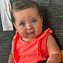Amelia is registered to the contest to win money with this photo: baby, child, blue_eyes, coral_clothing, couch, blanket, indoor, face, curly_hair, cute, infant, portrait, smiling, sitting, soft_light, person, home, closeup, happy, young_child
