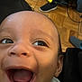 Kai joined the competition — help win amazing prizes! baby, close_up, smiling, happy, face, infant, blanket, whale_pattern, mouth_open, eyes, indoor, floor, wood_floor, shoe, footwear, black_shoe, blue_slipper, clothing, person, child