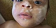 Kai is registered to the contest to win money with this photo: baby, face, powder, skin, eyes, nose, mouth, infant, child, expression, carpet, diaper, clothing, head, closeup, indoors, person, human, young, laying