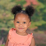 Alivia is registered to the contest to win money with this photo: african_american_child, child, childhood, cute, earrings, face, fashion, girl, hair_buns, happy, head_and_shoulders, innocence, outdoor_background, peach_dress, person, portrait, ruffles, smile, studio_photo, young_child