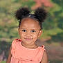 african_american_child, child, childhood, cute, earrings, face, fashion, girl, hair_buns, happy, head_and_shoulders, innocence, outdoor_background, peach_dress, person, portrait, ruffles, smile, studio_photo, young_child