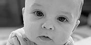 Everette joined the competition — help win amazing prizes! baby, infant, close_up, black_and_white, portrait, face, arms, chubby_cheeks, curious, eyes, expression, soft_background, cute, child, young, person, indoors, sleepwear, crawling, head