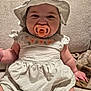 Jade joined the competition — help win amazing prizes! baby, pacifier, hat, dress, striped_clothing, couch, infant, child, sitting, smile, face, cheeks, hand, furniture, indoor, cute, young_child, person, fabric, relaxing