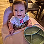 baby, high_chair, smiling, indoor, plate, divided_plate, mickey_mouse, clothing, person, child, wood_floor, table, chair, dining_room, happy, cute, feeding, meal, infant, straps