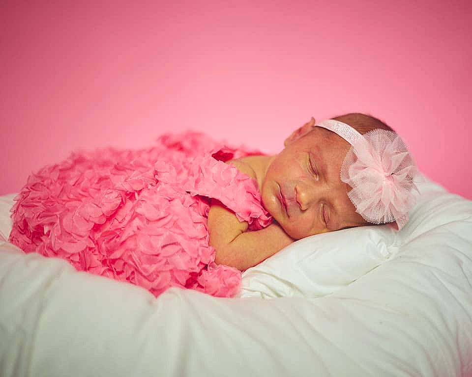 Presley is registered to the contest to win money with this photo: arm, baby, baby_sleeping, baby_toddler_clothing, bedtime, comfort, couch, dress, eye, flash_photography, hand, happy, head, headpiece, headwear, leg, linens, magenta, person, petal