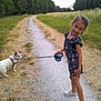 Lena participe au concours pour gagner de l'argent avec cette photo : child, girl, dog, leash, path, grass, trees, nature, outdoor, smile, summer, casual_clothing, footwear, walking, pet, playful, greenery, romper, happy, park
