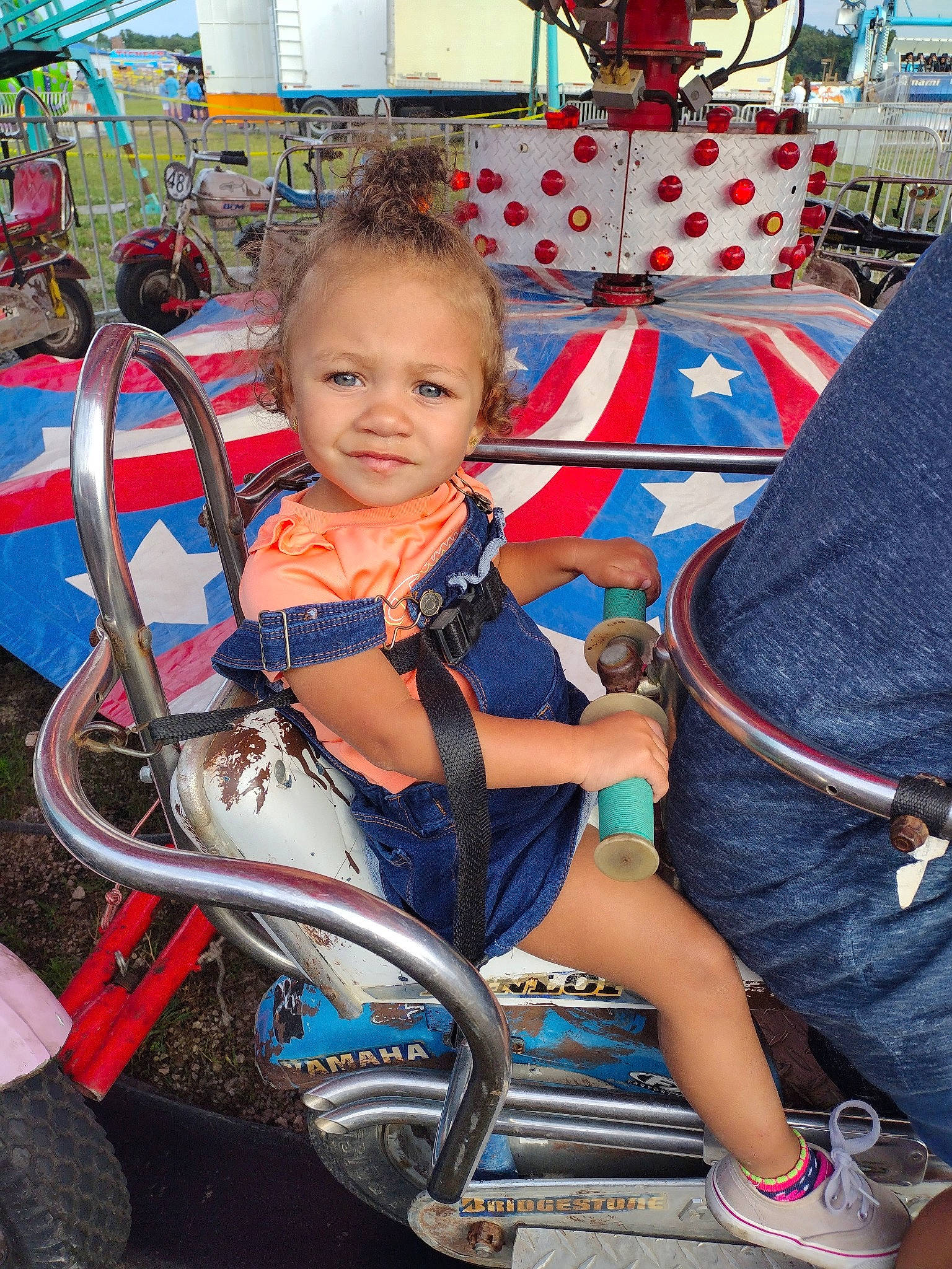 Corina is registered to the contest to win money with this photo: automotive_tire, baby_carriage, baby_products, child, city, electric_blue, event, fun, happy, joy, leisure, motor_vehicle, person, play, recreation, rim, sitting, smile, spoke, tire