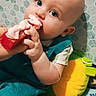 Frank joined the competition — help win amazing prizes! baby, bib, blanket, blue_eyes, child, close_up, colorful, curious, hands, indoor, infant, patterned_background, plush_turtle, portrait, red_toy, short_sleeves, sitting, smiling, teething, toy