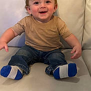 Codye is registered to the contest to win money with this photo: toddler, child, smiling, socks, jeans, tshirt, couch, leather, indoor, hair, happy, sitting, person, clothing, young_child, cute, face, expression, furniture, casual