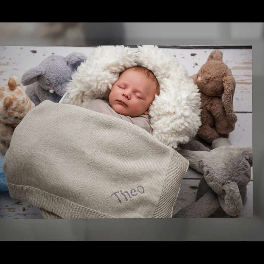 Theo is registered to the contest to win money with this photo: adult, baby, blanket, bodypart, bonnet, cap, clothing, face, finger, hand, hat, head, hood, male, man, newborn, person, photography, portrait, sleeping