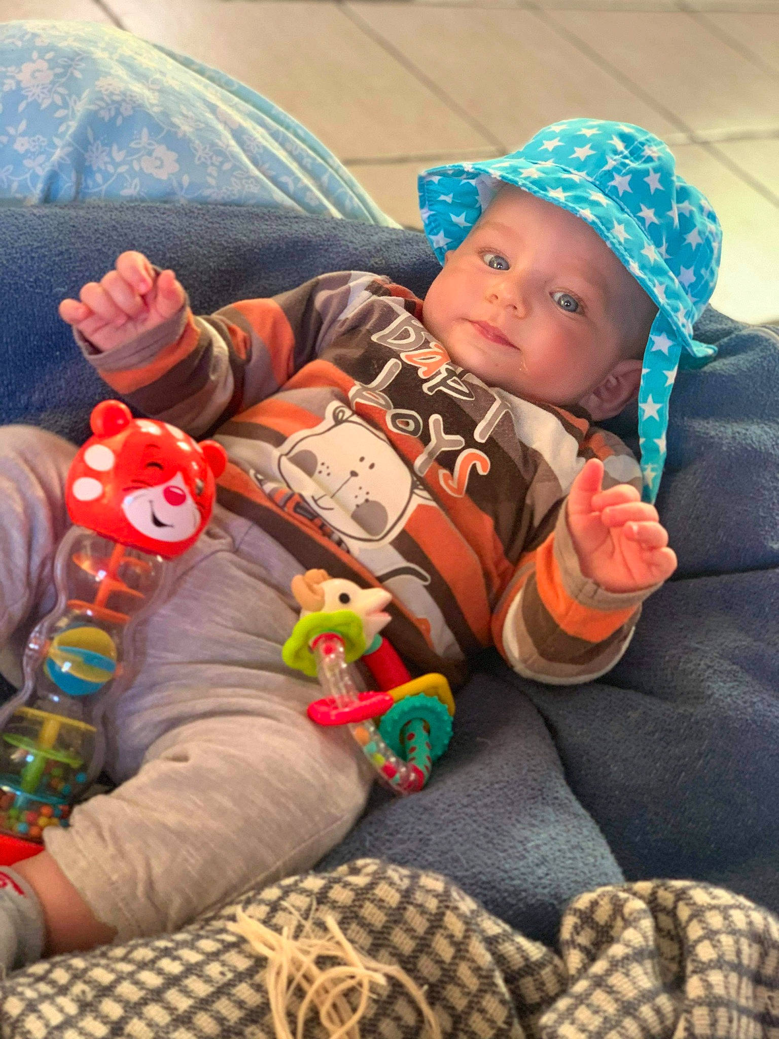 Wyatt participe au concours pour gagner de l'argent avec cette photo : baby, baby_products, baby_toddler_clothing, cap, child, comfort, finger, fun, happy, headwear, human_body, lap, linens, mouth, orange, person, play, sitting, skin, textile