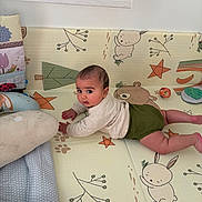 Sohan participe au concours pour gagner de l'argent avec cette photo : baby, child, playmat, green_shorts, beige_top, animal_prints, stars, cute, indoor, floor, soft_toys, pillow, curious, looking_back, infant, toddler, colorful, decor, play_area, young_child