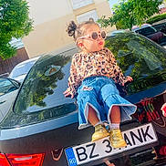 Sofia a rejoint le concours — aidez-le/la à gagner de superbes lots ! baby, brownhair, bumper, car, clothing, curlyhair, fun, hair, headlight, jeans, licenseplate, pants, person, sitting, sleeve, text, tire, transportation, vacation, vehicle