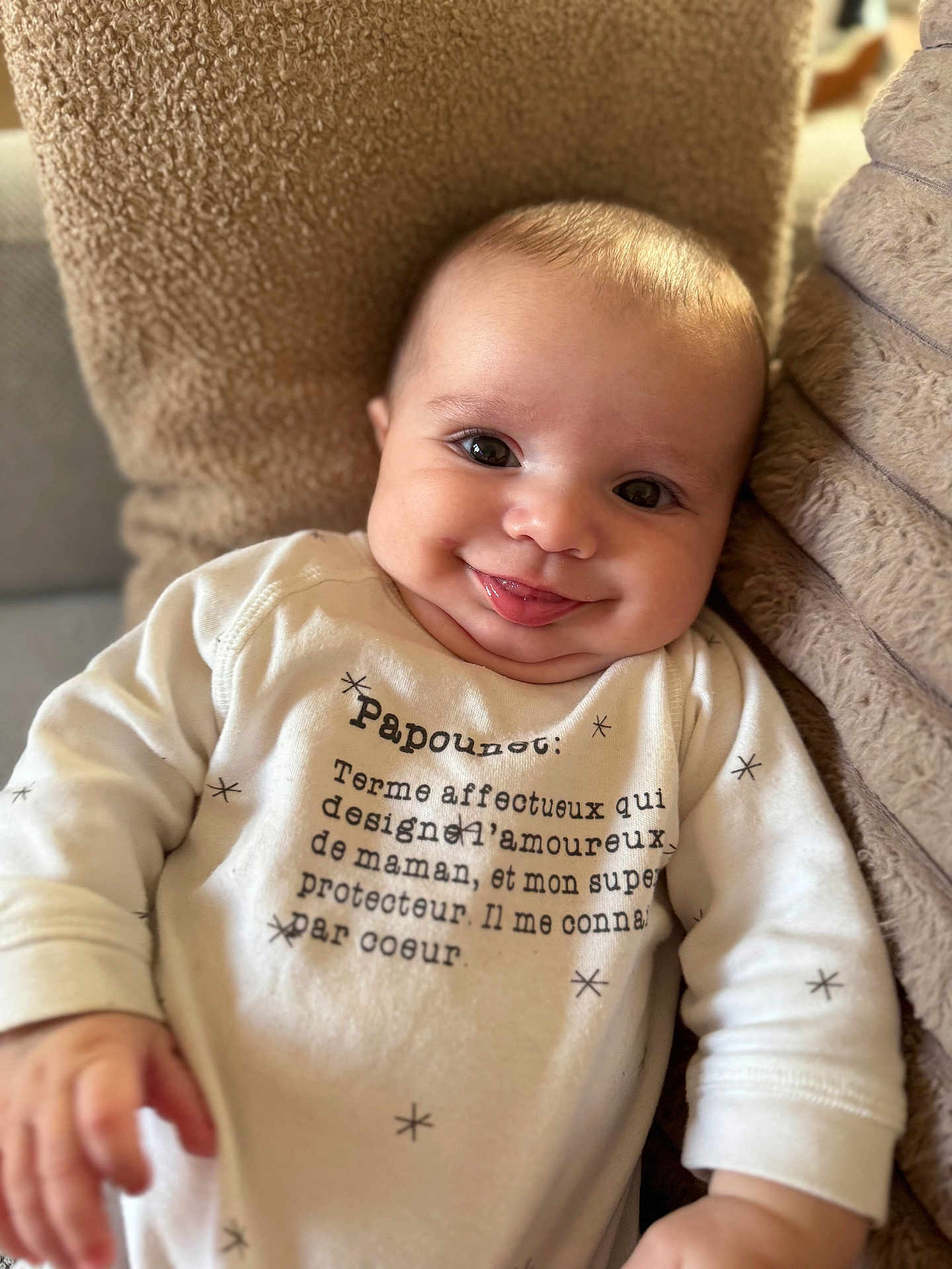 Nowen a rejoint le concours — aidez-le/la à gagner de superbes lots ! baby, infant, smile, tongue_out, onesie, cushion, soft_texture, face, cheeks, happy, cute, child, portrait, indoor, closeup, clothing, cozy, expression, person, newborn