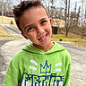 background, boy, candid, casual_clothing, child, daylight, driveway, expression, face, green_hoodie, happy, hoodie, nature, outdoor, person, portrait, smiling, spiky_hair, trees, young