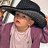 Ellianna is registered to the contest to win money with this photo: toddler, child, hat, black_hat, pink_shirt, jacket, shopping_aisle, curious, face, person, clothing, store, retail, indoor, expression, young_child, headwear, casual, portrait, holding_hat