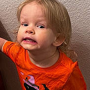 Ellianna is registered to the contest to win money with this photo: bat, black_cat, bright_colors, casual_clothing, child, curly_hair, cute, expression, fun, halloween, indoor, orange_shirt, person, playful, portrait, smile, texture, toddler, wall, young_child