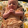 adorable, animal_print, baby, cheerful, child, clothing, comfortable, cute, frills, hands, headband, indoors, infant, person, pillow, playful, sitting, smile, soft_lighting, young_child