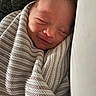 baby, newborn, sleeping, smiling, blanket, striped, cozy, wrapped, infant, face, closeup, soft, peaceful, cute, child, portrait, indoors, head, resting, warm