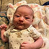 baby, infant, smiling, onesie, blanket, cute, face, skin, hand, lying_down, pattern, animal_print, comfort, cozy, indoors, child, soft, expression, newborn, portrait