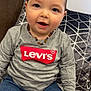 Samaël participe au concours pour gagner de l'argent avec cette photo : toddler, child, smiling, mohawk, beaded_necklace, gray_shirt, levis, blue_jeans, couch, pillow, geometric_pattern, indoor, portrait, happy, young_child, casual_clothing, home, sitting, face, person