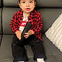 Mathys participe au concours pour gagner de l'argent avec cette photo : toddler, child, remote_control, couch, gray_couch, red_checkered_shirt, white_tshirt, black_pants, white_socks, indoor, curly_hair, cute, sitting, portrait, furniture, pillow, levis, looking_away, home, casual_clothing