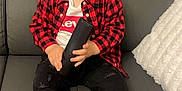 Mathys participe au concours pour gagner de l'argent avec cette photo : toddler, child, couch, remote_control, red_shirt, black_pants, white_socks, levis, plaid, indoor, portrait, sitting, cute, young_child, hair, face, expression, home, pillow, furniture