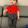 Mathys a rejoint le concours — aidez-le/la à gagner de superbes lots ! toddler, child, red_shirt, suspenders, checkered_pants, barefoot, gray_couch, indoor, curly_hair, blue_eyes, standing, looking_up, furniture, home, cute, portrait, young_child, casual_clothing, relaxed, light_skin