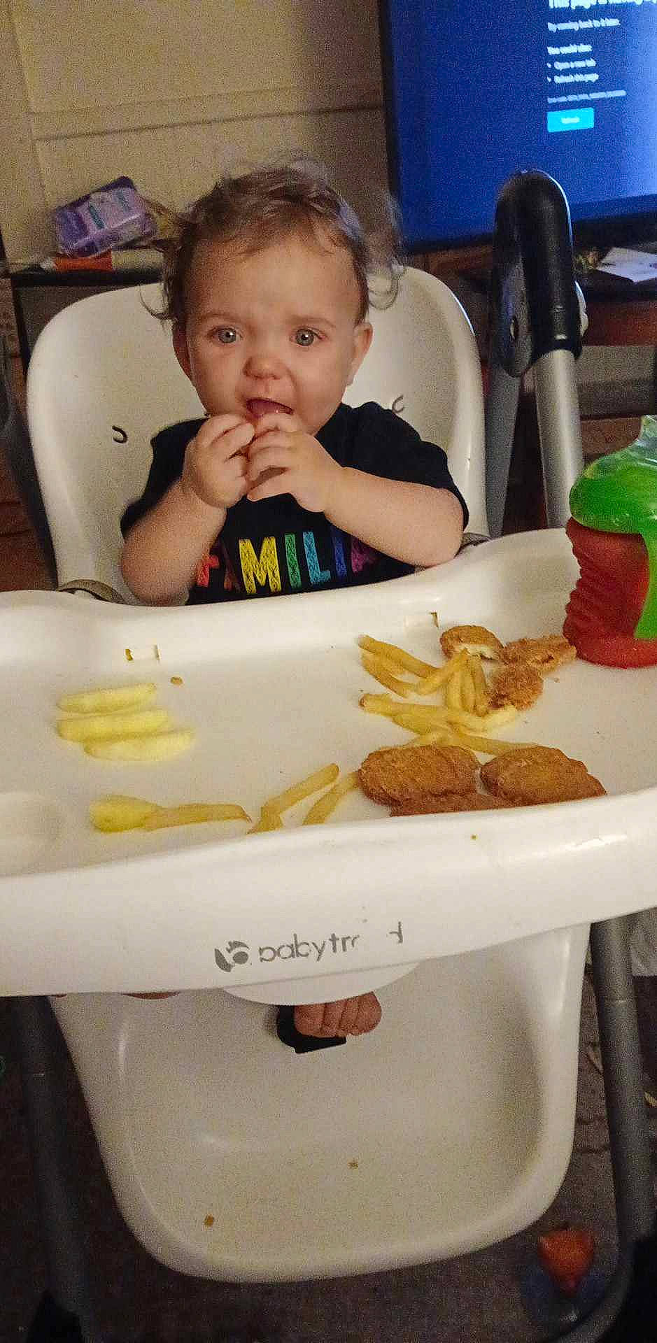 Astrid is registered to the contest to win money with this photo: baby, biting, chair, child, comfort_food, cuisine, dish, face, food, food_craving, fruit, ingredient, junk_food, organ, person, plate, saba_banana, sharing, tableware, toddler