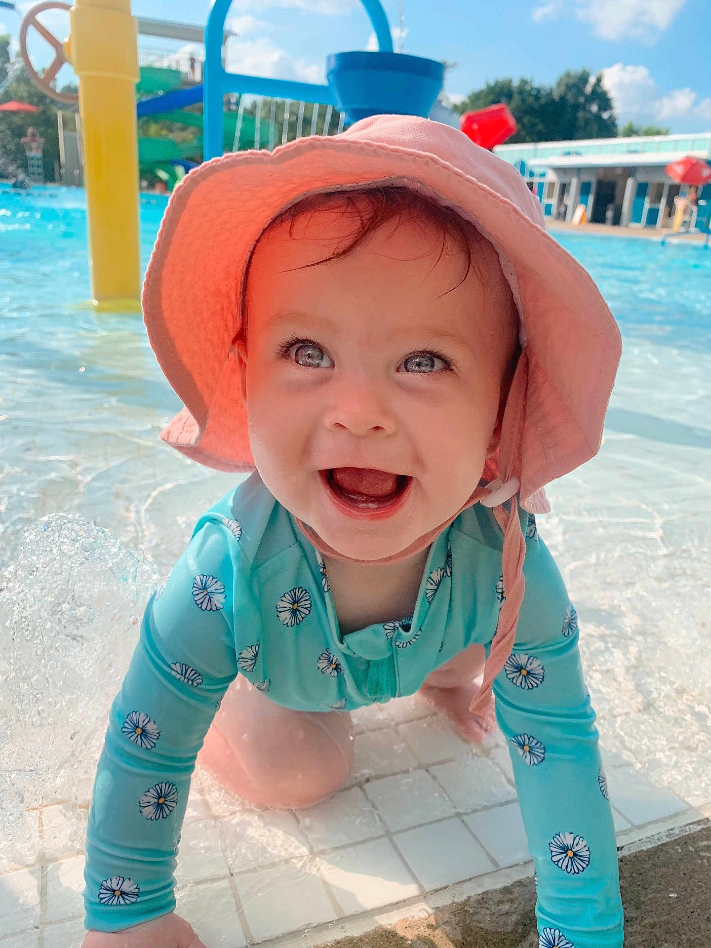 Claire joined the competition — help win amazing prizes! baby, child, smiling, sunhat, swimsuit, water, pool, splash, outdoor, happy, blue_sky, summer, playground, sunny, crawling, face, person, daylight, recreation, fun
