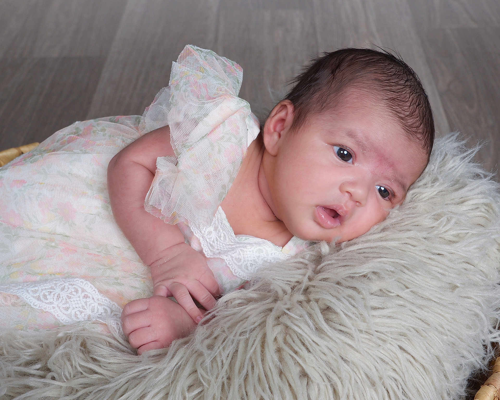 Saanvika is registered to the contest to win money with this photo: baby, infant, newborn, dress, lace, floral, cushion, soft_texture, wooden_floor, portrait, hands, face, head, skin, cute, lying_down, indoors, child, young, resting