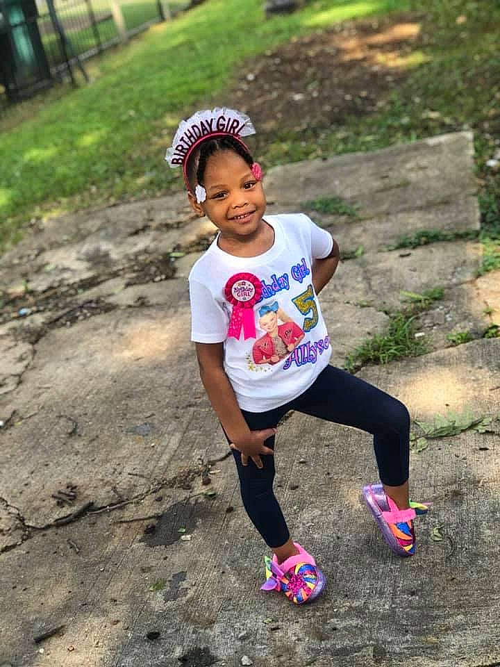 Allyson is registered to the contest to win money with this photo: asphalt, athlete, baseball_cap, cap, competition_event, eye, fun, grass, happy, joy, leisure, outdoor_recreation, person, plant, recreation, running, shorts, sneakers, soil, sportswear