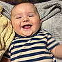 Axel is registered to the contest to win money with this photo: baby, smiling, striped_shirt, blanket, happy, infant, face, child, lying_down, cozy, cute, skin, cheeks, indoor, young_child, person, head, expression, clothing, comfort