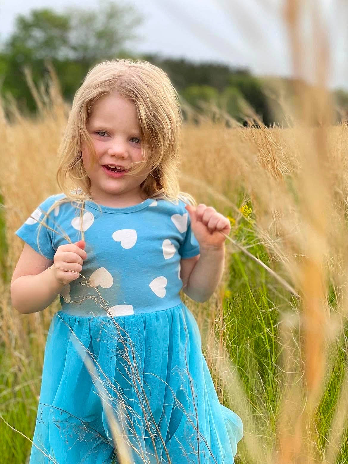 Mckynlee joined the competition — help win amazing prizes! baby_toddler_clothing, blond, day_dress, dress, electric_blue, grass, grassland, hair, happy, meadow, one_piece_garment, pattern, people_in_nature, person, plant, prairie, sleeve, summer, toddler, tree