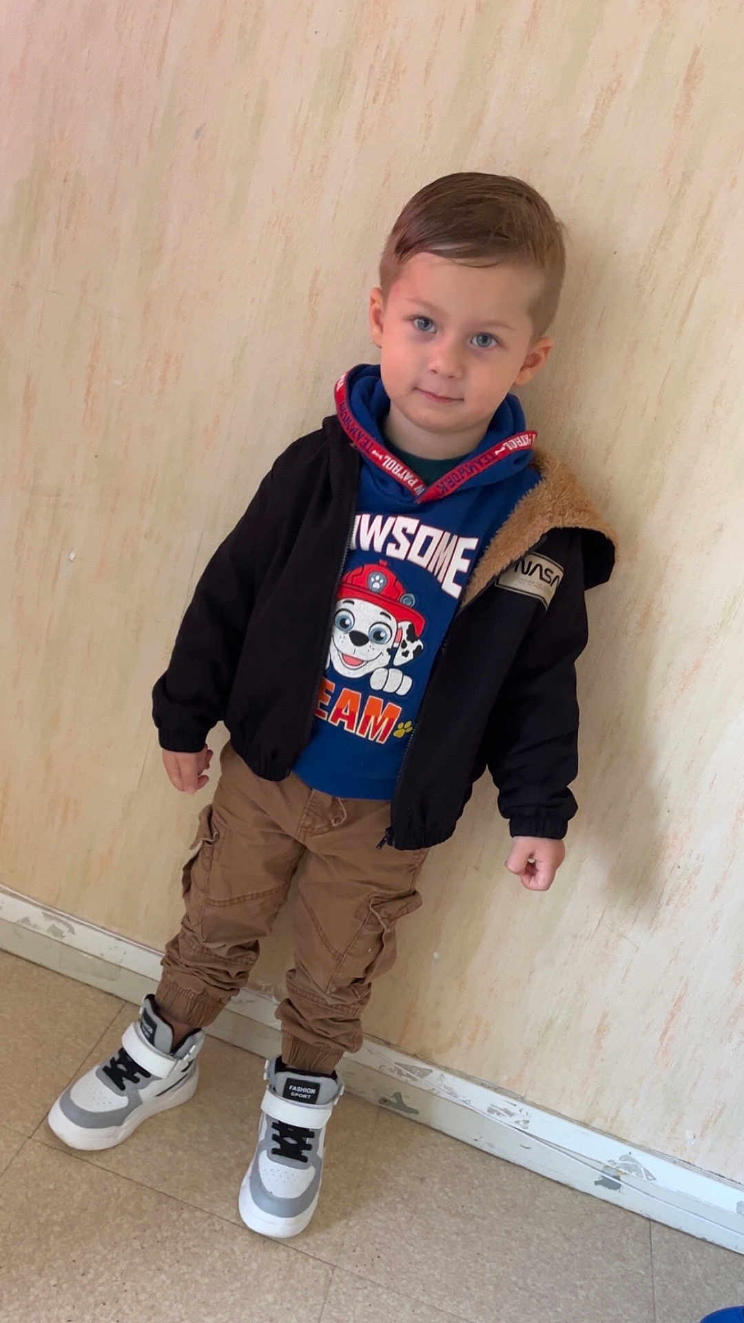 Mylan a rejoint le concours — aidez-le/la à gagner de superbes lots ! blue_eyes, boy, cargo_pants, cartoon, casual_clothing, child, cute, fashion_sport, floor, footwear, hoodie, indoor, jacket, pants, person, portrait, sneakers, standing, wall, young