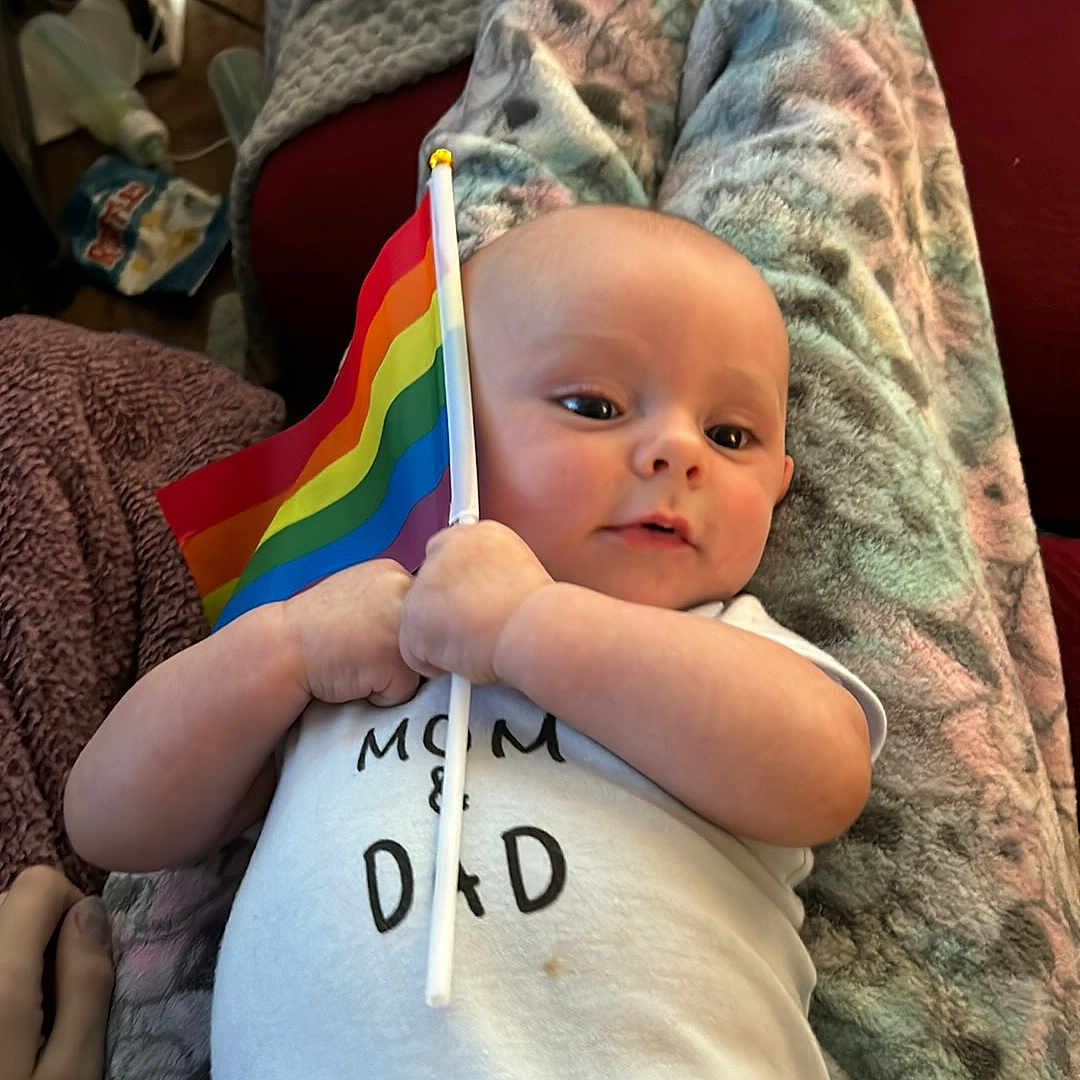 Orion is registered to the contest to win money with this photo: baby, blanket, bodypart, clothing, couch, cushion, face, finger, flag, furniture, hand, hat, head, homedecor, newborn, person, photography, portrait, quilt, t_shirt