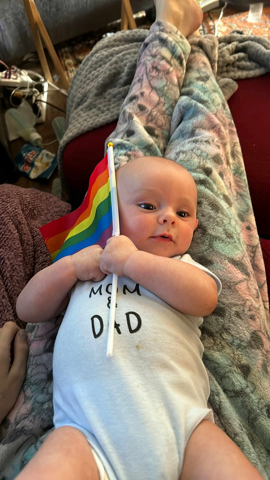 Orion is registered to the contest to win money with this photo: baby, blanket, bodypart, clothing, couch, cushion, face, finger, flag, furniture, hand, hat, head, homedecor, newborn, person, photography, portrait, quilt, t_shirt