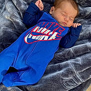 Abelino joined the competition — help win amazing prizes! baby, infant, sleeping, blanket, blue_outfit, nike_logo, logo, clothing, face, closed_eyes, hand, fingers, blanket_texture, soft_fabric, cozy, newborn, portrait, skin, hair, resting