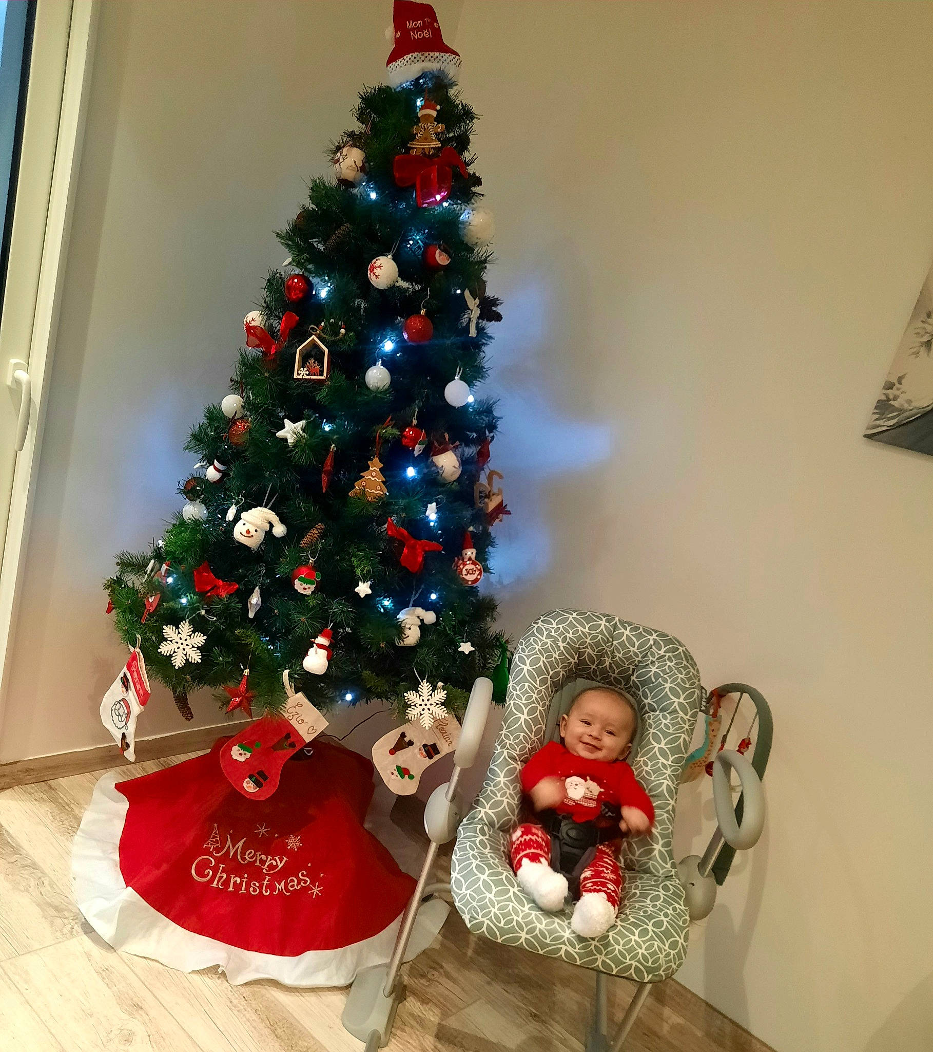 Ezio a rejoint le concours — aidez-le/la à gagner de superbes lots ! christmas, christmas_decoration, christmas_eve, christmas_lights, christmas_ornament, christmas_tree, conifer, event, evergreen, holiday, holiday_ornament, joy, living_room, ornament, person, plant, room, toy, tradition, tree