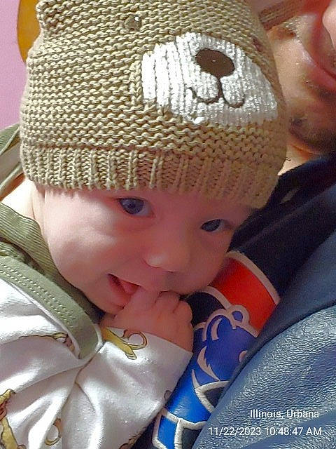 Archer is registered to the contest to win money with this photo: art, baby, beanie, cap, child, costume_hat, crochet, doll, fashion, fashion_accessory, fur, happy, headwear, knit_cap, pattern, person, product, toddler, tree, winter
