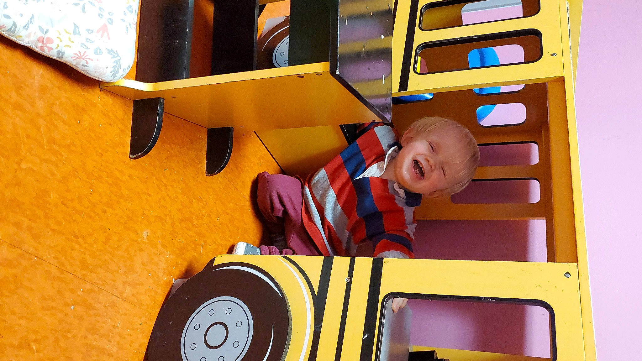 Asher is registered to the contest to win money with this photo: automotive_tire, automotive_wheel_system, baby, baby_toddler_clothing, child, fun, leisure, motor_vehicle, person, play, playground, recreation, riding_toy, rolling, room, smile, tire, toddler, wheel, wood