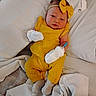 baby, infant, yellow_outfit, headband, bow, mittens, bed, blanket, white_sheets, lying_down, cute, child, person, sock, cozy, indoors, portrait, newborn, fashion, soft_lighting