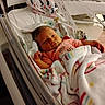 Ashlynn joined the competition — help win amazing prizes! newborn, baby, hospital, bassinet, blanket, clothing, infant, sleepy, pink, person, cute, wrapped, resting, indoor, soft, toddler, face, hand, bed, cozy