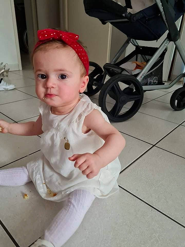 Fatima El Zoh participe au concours pour gagner de l'argent avec cette photo : baby, baby_products, baby_safety, baby_toddler_clothing, child, costume, costume_hat, fashion_accessory, floor, flooring, fun, hat, headband, human_leg, pattern, person, sitting, sleeve, t_shirt, toddler